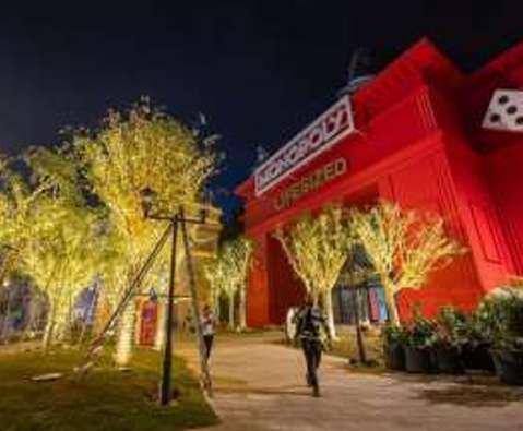 Up-lit trees in front of a themed building at night