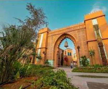 Moroccan-style gateway framed by palms and planting