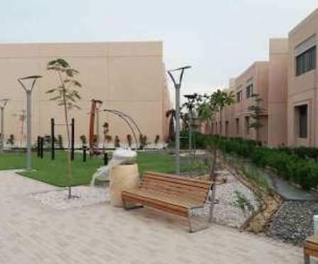 Landscaped courtyard with bench, trees and fitness equipment