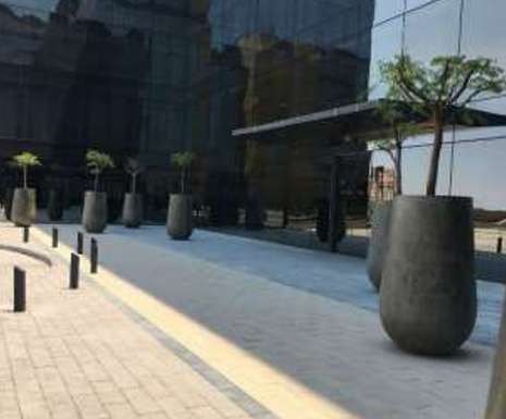 Forecourt paving with bollards and tree planters